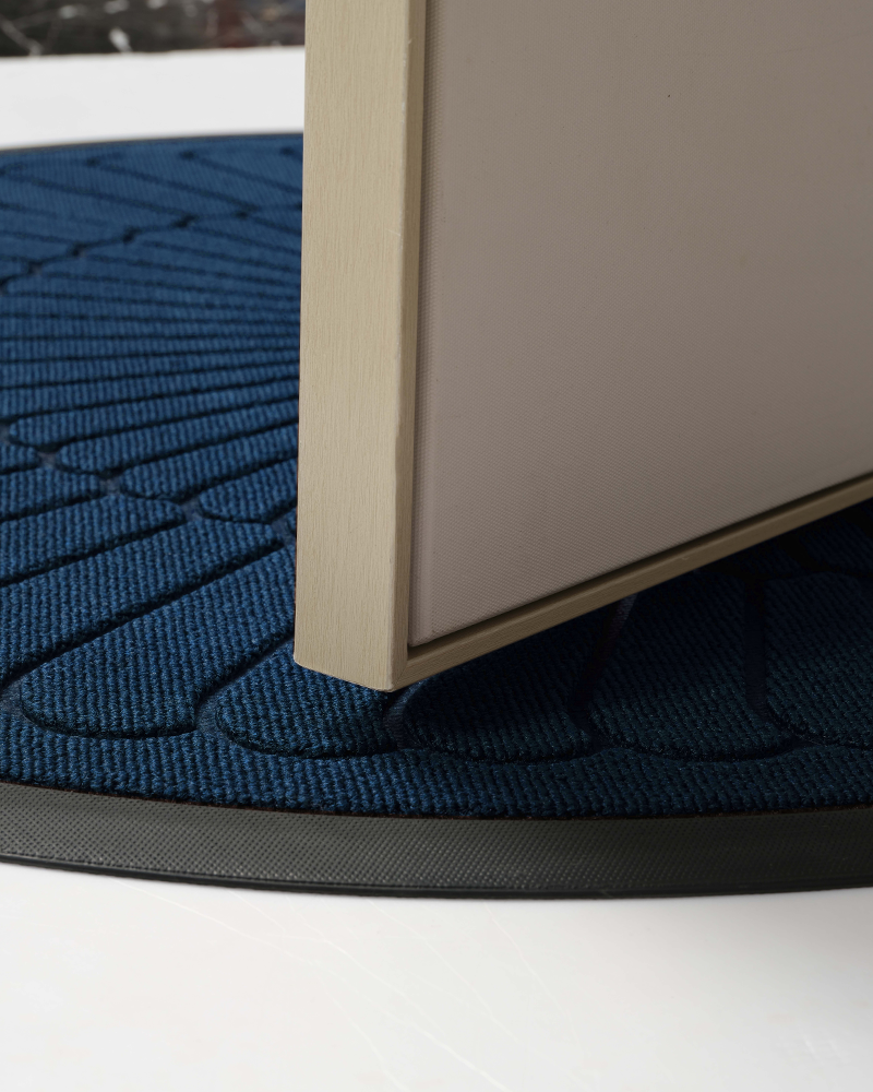 Durable half-round outdoor entry mat made of textured rubber and polyester.