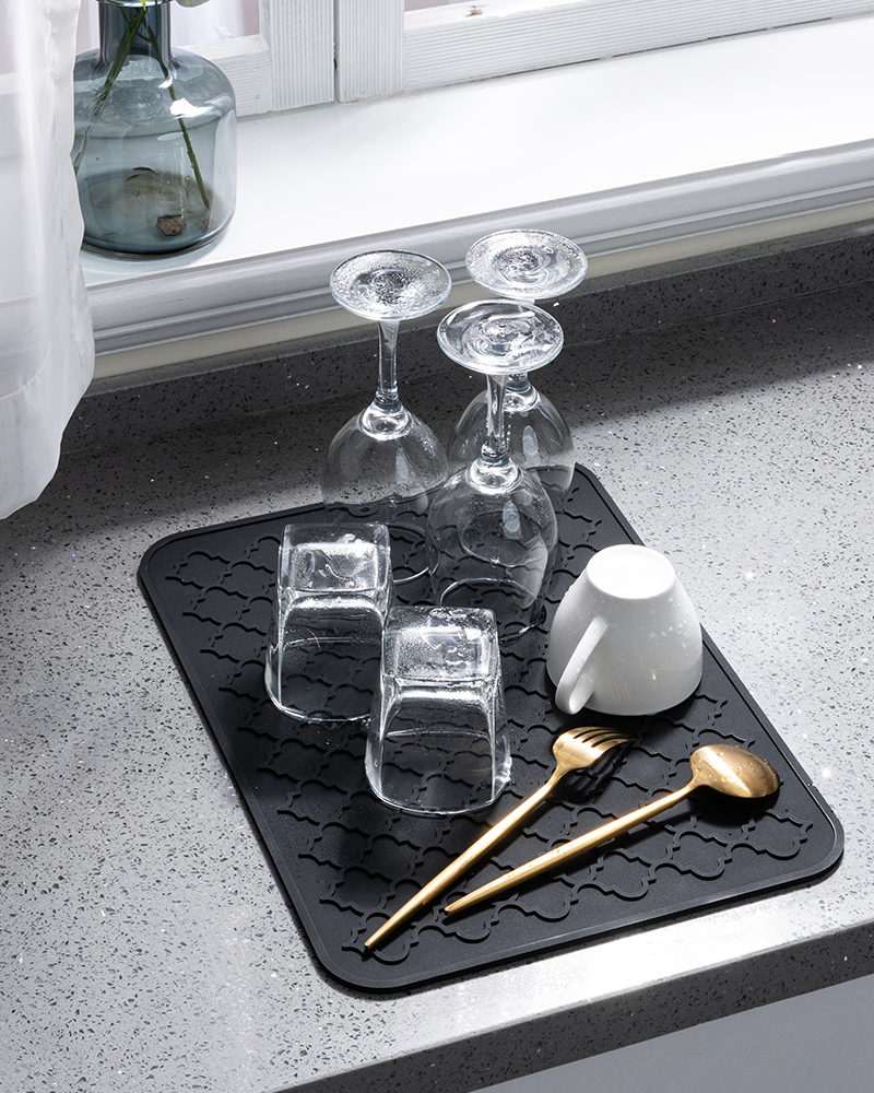 Silicone drying mat for dishes and utensils, easy to clean and heat-resistant.