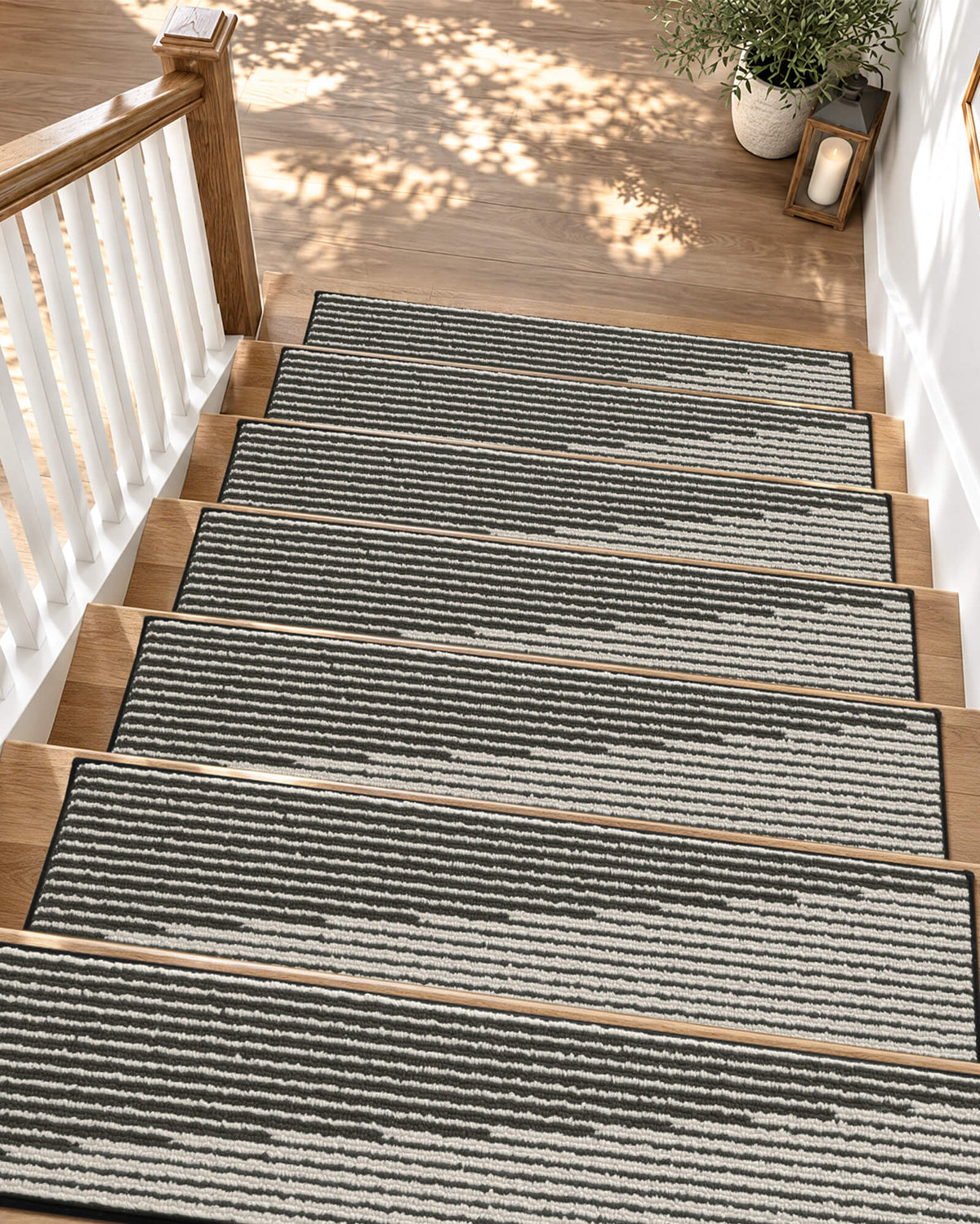 Black and white striped non-slip stair treads add modern style and everyday comfort to a sunlit wooden staircase, featuring a soft ribbed texture, neatly bound edges, and a secure anti-slip design that provides comfortable footing and helps protect hardwood steps in busy family homes.
