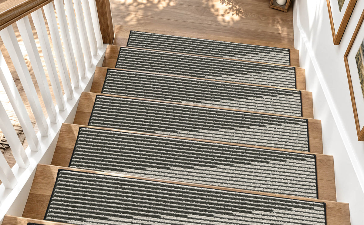 Black and white striped woven stair treads neatly cover a sunlit wooden staircase, featuring a textured ribbed surface, clean bound edges, and a modern linear pattern that adds comfortable footing, everyday protection, and timeless style to indoor stairs.