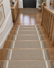 Brown gradient striped non-slip stair treads neatly line a wooden staircase leading to a welcoming entryway, featuring a soft raised diagonal woven texture, contrasting white accent stripes, and neatly bound edges that provide comfortable footing, help protect hardwood steps, and add warm, modern style to everyday home interiors.