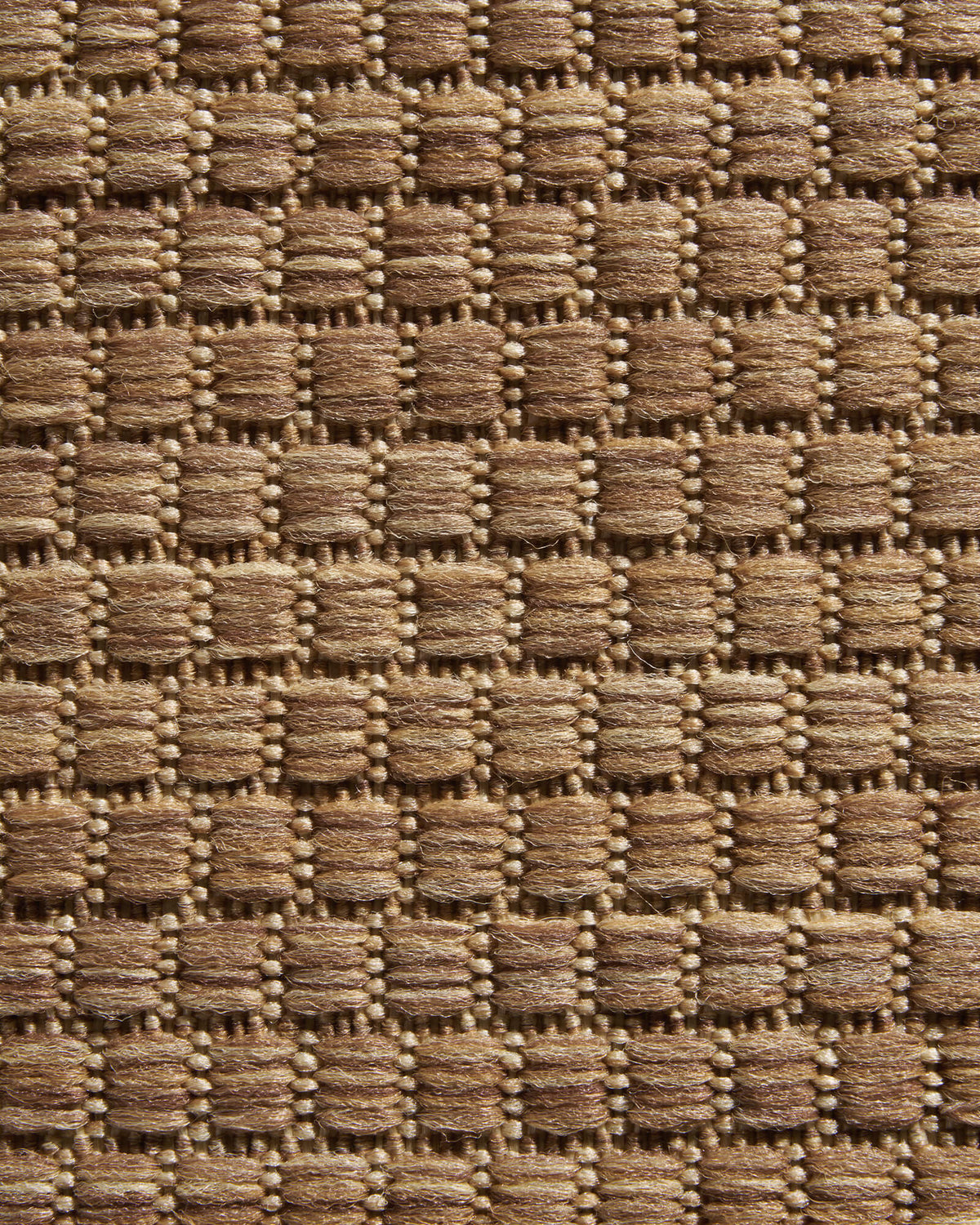 A close-up view of a brown plain weave outdoor rug highlights its raised basketweave texture, durable woven surface, and natural outdoor style for patios, decks, porches, and entryway spaces.
