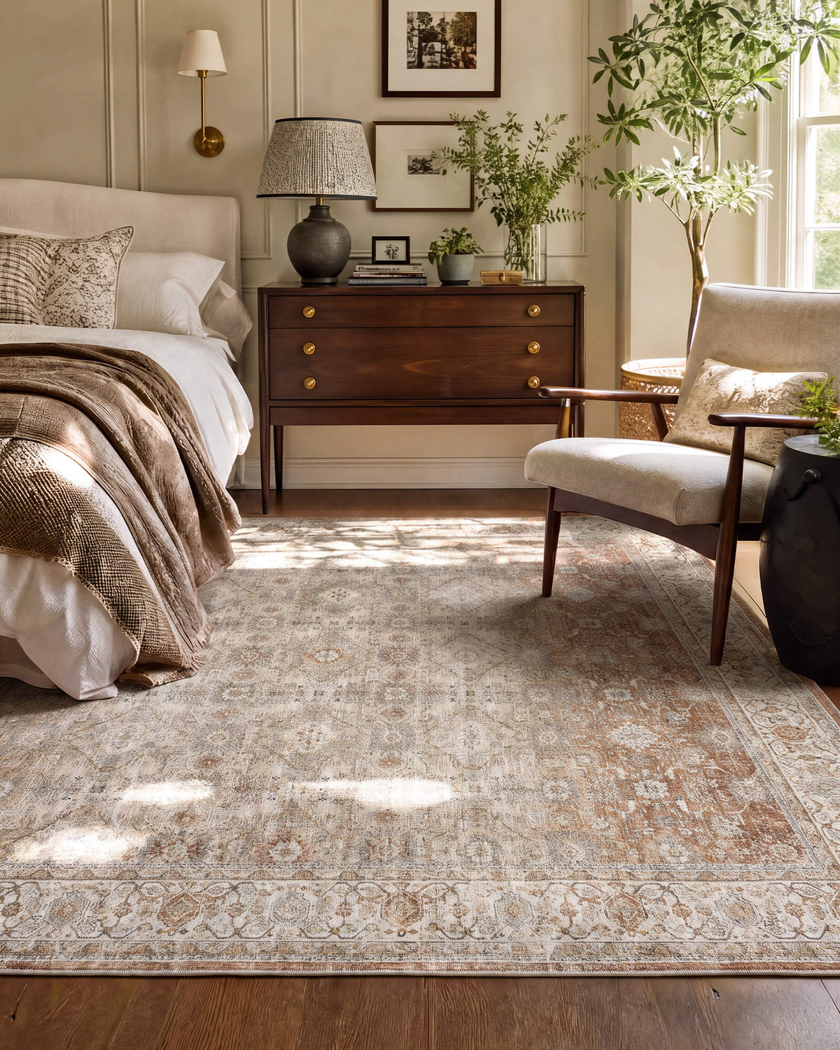 A brown vintage washable area rug with a distressed medallion pattern and ornate border adds warm neutral charm to a cozy bedroom with wood furniture, soft bedding, natural light, and classic home decor.