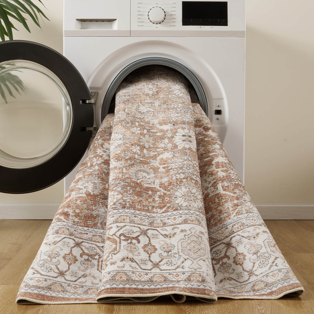 A brown vintage washable area rug is shown in a washing machine, featuring a distressed floral medallion pattern, ornate border details, and an easy-care design for living rooms, bedrooms, and busy family homes.