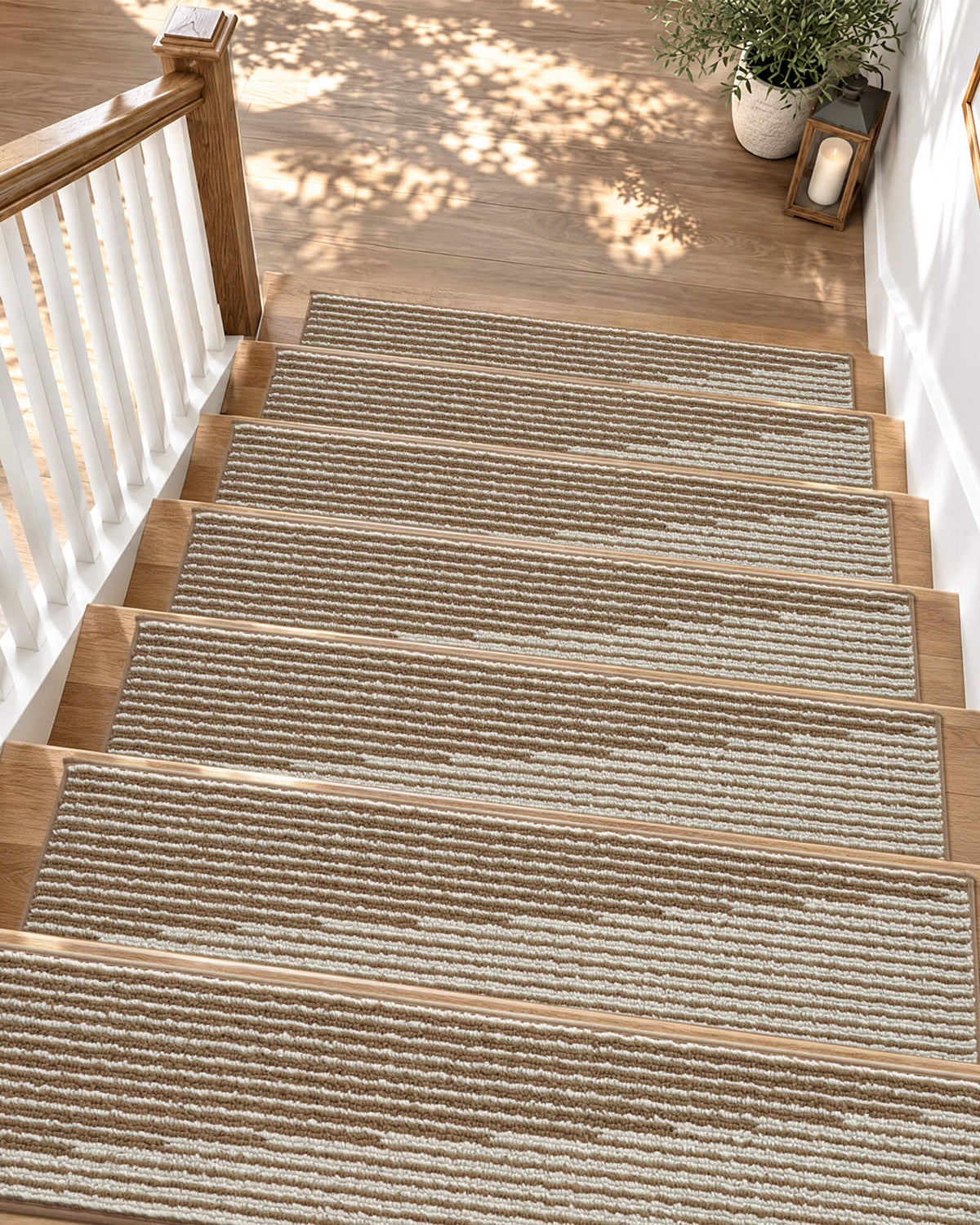 Brown and white striped non-slip stair treads add warm, timeless style to a sunlit wooden staircase, featuring a soft ribbed woven texture, neatly bound edges, and a secure anti-slip backing that provides comfortable footing, helps protect hardwood steps, and enhances everyday comfort for families with kids and pets.