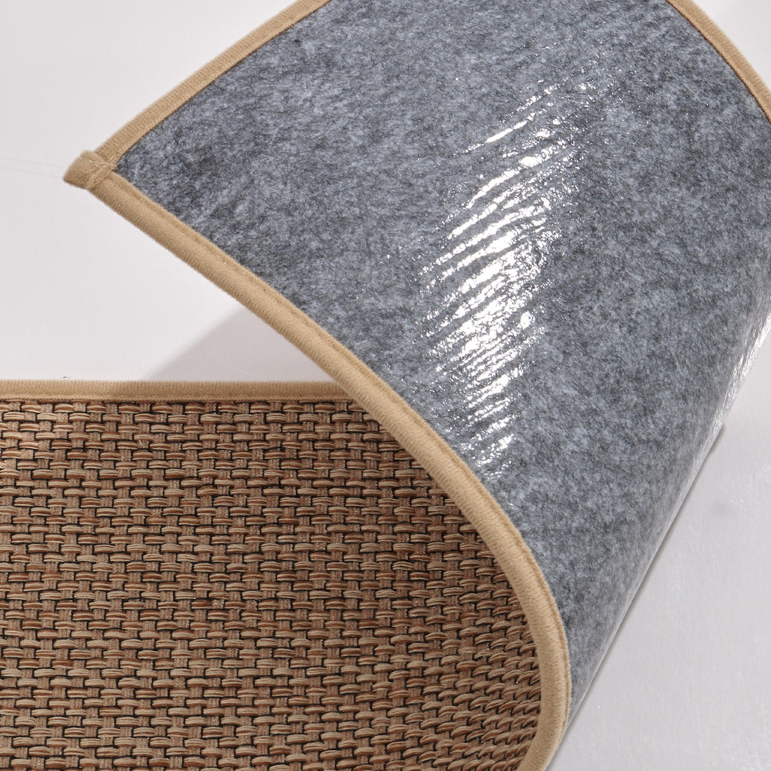 A close-up of a brown woven non-slip stair tread mat shows its folded corner, textured polypropylene woven surface, gray adhesive backing, and neatly reinforced edges, highlighting easy peel-and-stick installation, secure grip, and residue-free removal for indoor wooden staircases.
