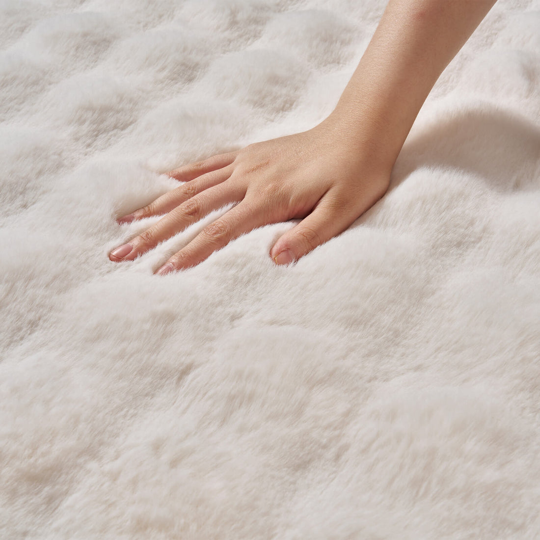 A close-up of a hand gently pressing into a cream Cloud Soft shag area rug highlights its ultra-plush long-pile fibers, irresistibly fluffy texture, and cloud-like cushioning, showcasing exceptional softness and luxurious comfort for cozy bedrooms, living rooms, and barefoot relaxation.