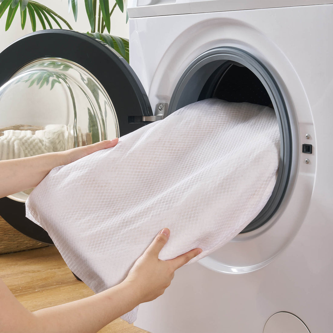 A cream Cloud Soft shag area rug is shown being placed in a front-loading washing machine, highlighting its convenient washable design, soft quilted backing, and easy-care comfort for cozy bedrooms, living rooms, and family-friendly spaces.