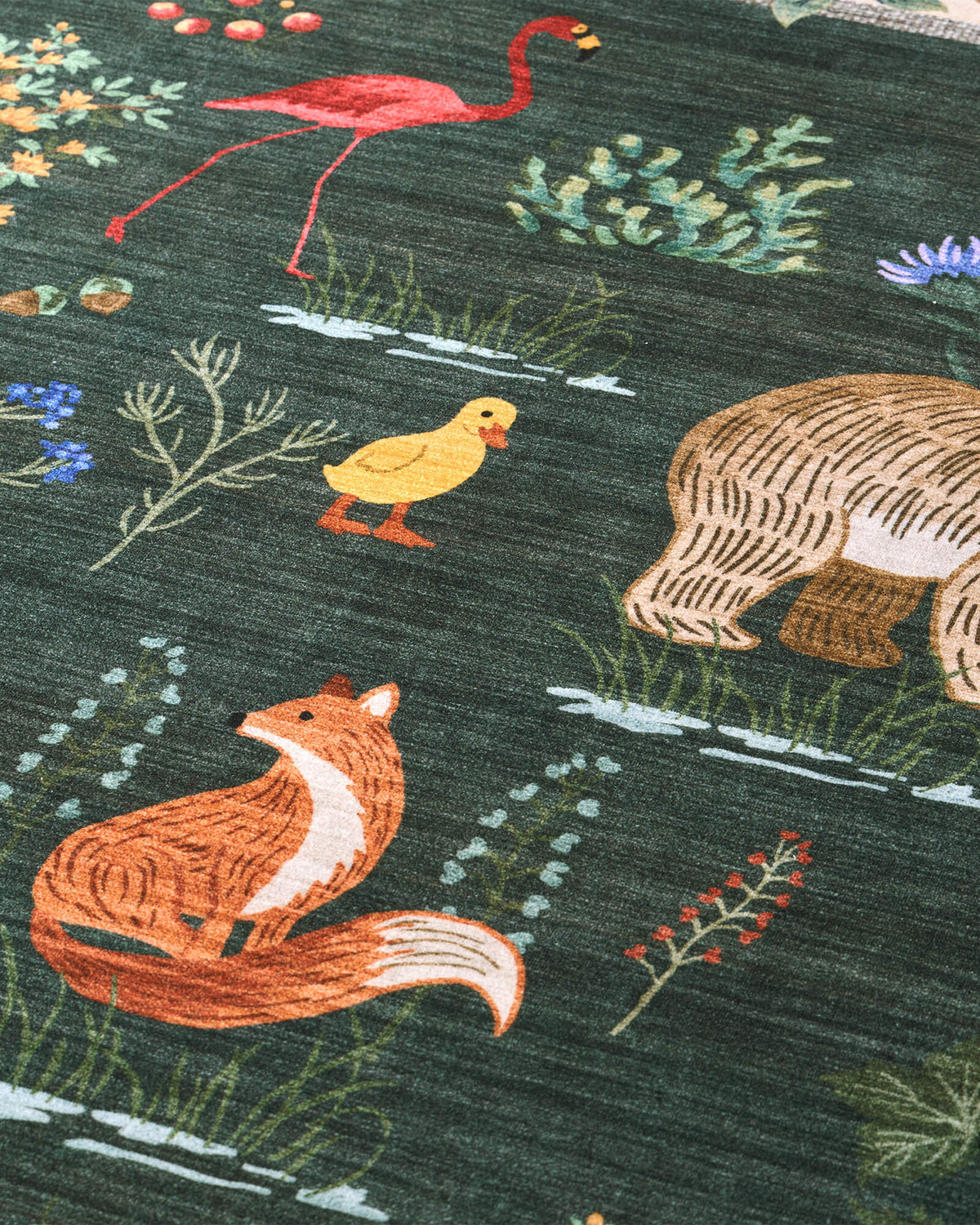 A close-up view of a dark green soft kids rug highlights its cute fox, flamingo, duck, forest animal, and botanical illustrations, offering a gentle comfortable surface and playful charm for nurseries, playrooms, and children’s bedrooms.