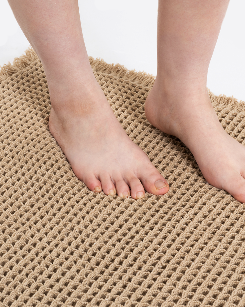 Decorative bath mat featuring tassel border and textured weave that enhances modern and cozy interiors