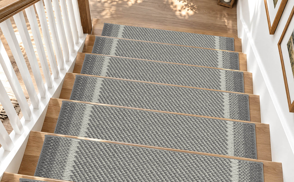 Gray gradient striped non-slip stair treads neatly line a sunlit wooden staircase, featuring a textured woven surface, subtle ombre stripe pattern, and contrasting light accents that provide comfortable footing, help protect hardwood steps, and add modern, understated style to family-friendly home interiors.