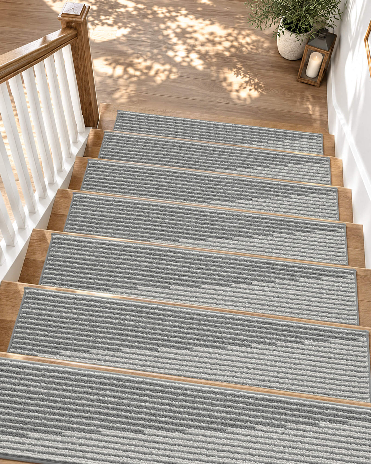 Gray and white striped non-slip stair treads add modern style and everyday comfort to a sunlit wooden staircase, featuring a soft ribbed woven texture, neatly bound edges, and a secure anti-slip backing that provides comfortable footing, helps protect hardwood steps, and enhances safety for kids and pets in busy family homes.