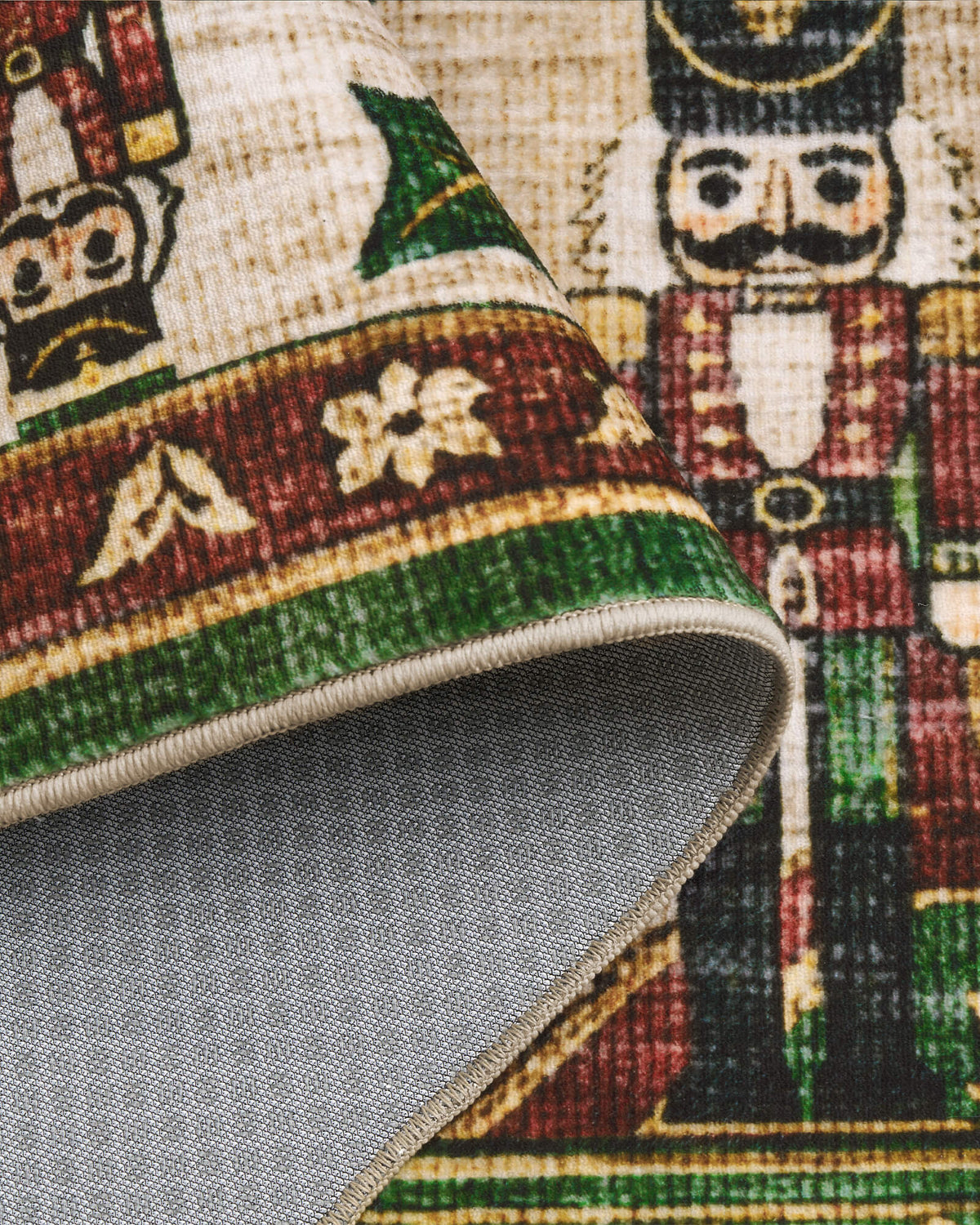 A close-up of a green Christmas vintage washable area rug highlights its folded corner, textured gray non-slip backing, neatly bound edge, and detailed nutcracker soldier and festive ornamental border patterns in rich green, burgundy, and cream tones, combining practical everyday comfort with nostalgic holiday charm.