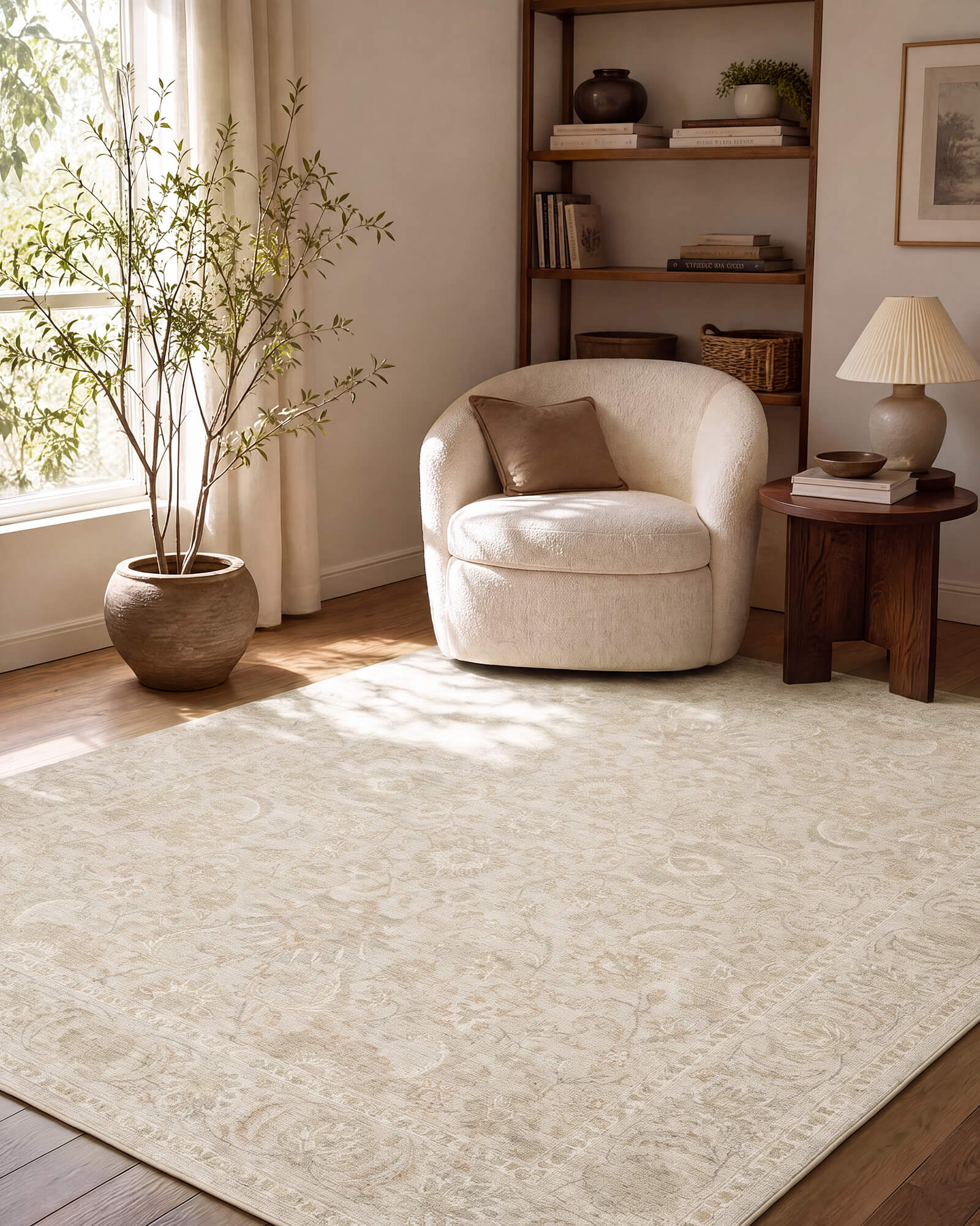 An ivory beige vintage washable area rug with a subtle ornamental medallion pattern creates a cozy reading corner with a boucle accent chair, wood side table, natural sunlight, and warm neutral decor.