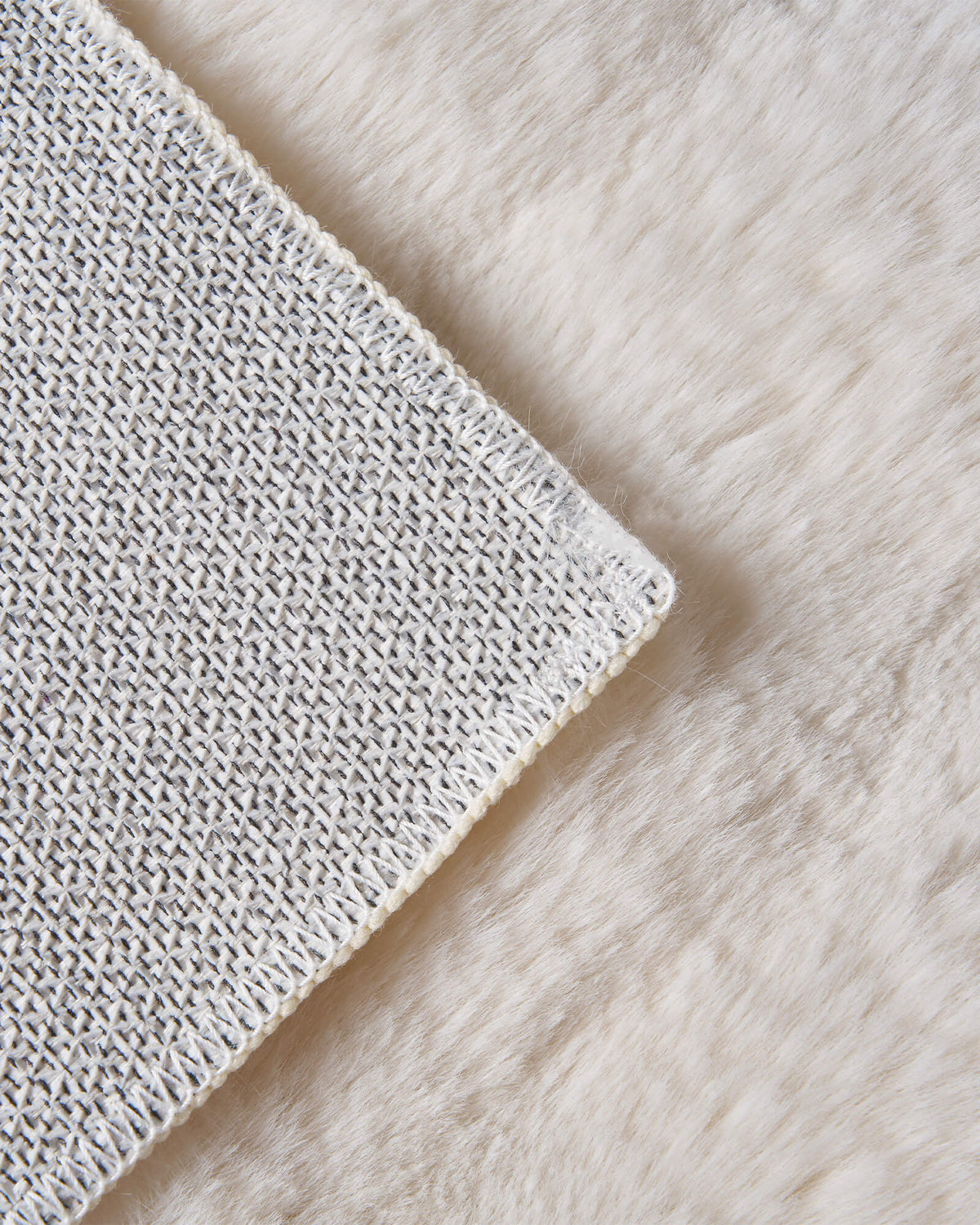 A close-up of an ivory Cloud Soft shag area rug highlights its ultra-plush long-pile fibers, silky cloud-like texture, and textured non-slip backing, offering exceptional softness and cozy barefoot comfort for bedrooms, living rooms, and relaxing home spaces.