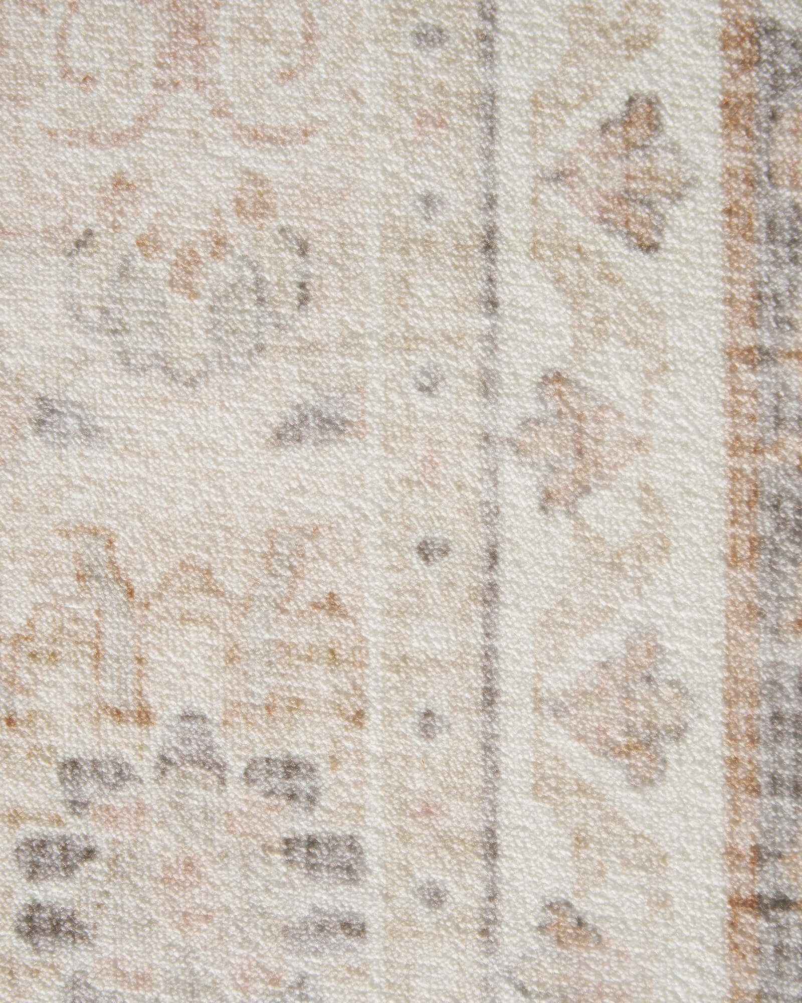 A close-up view of an ivory neutral vintage washable rug highlighting its distressed ornamental border lines, soft low-pile texture, and subtle faded details for elegant living room and bedroom decor.