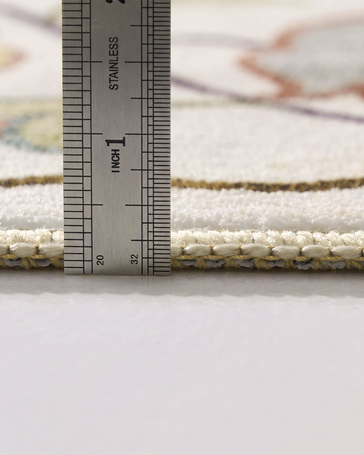 A close-up view of an ivory soft kids rug showing its ruler-measured pile height, plush comfortable surface, and neatly bound edge for safe and cozy nursery, playroom, and children’s bedroom use.