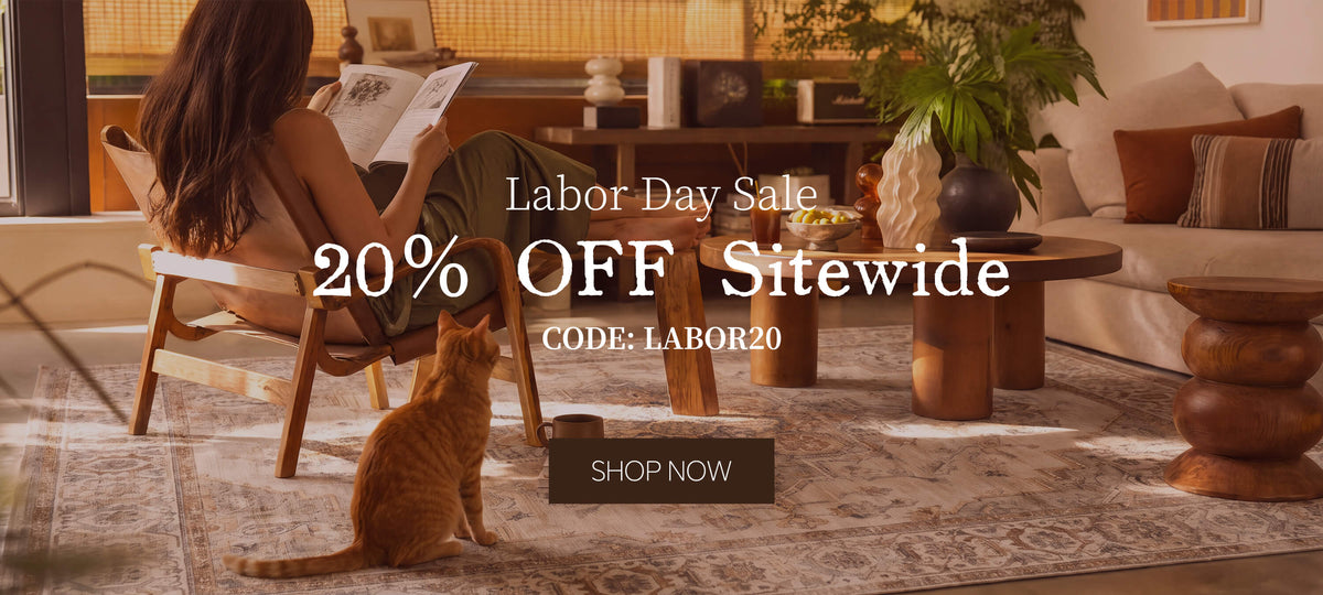A Labor Day sale banner for washable area rugs featuring a cozy living room scene, warm sunlight, a reading corner, a cat, and promotional text for 20% off sitewide with code LABOR20.