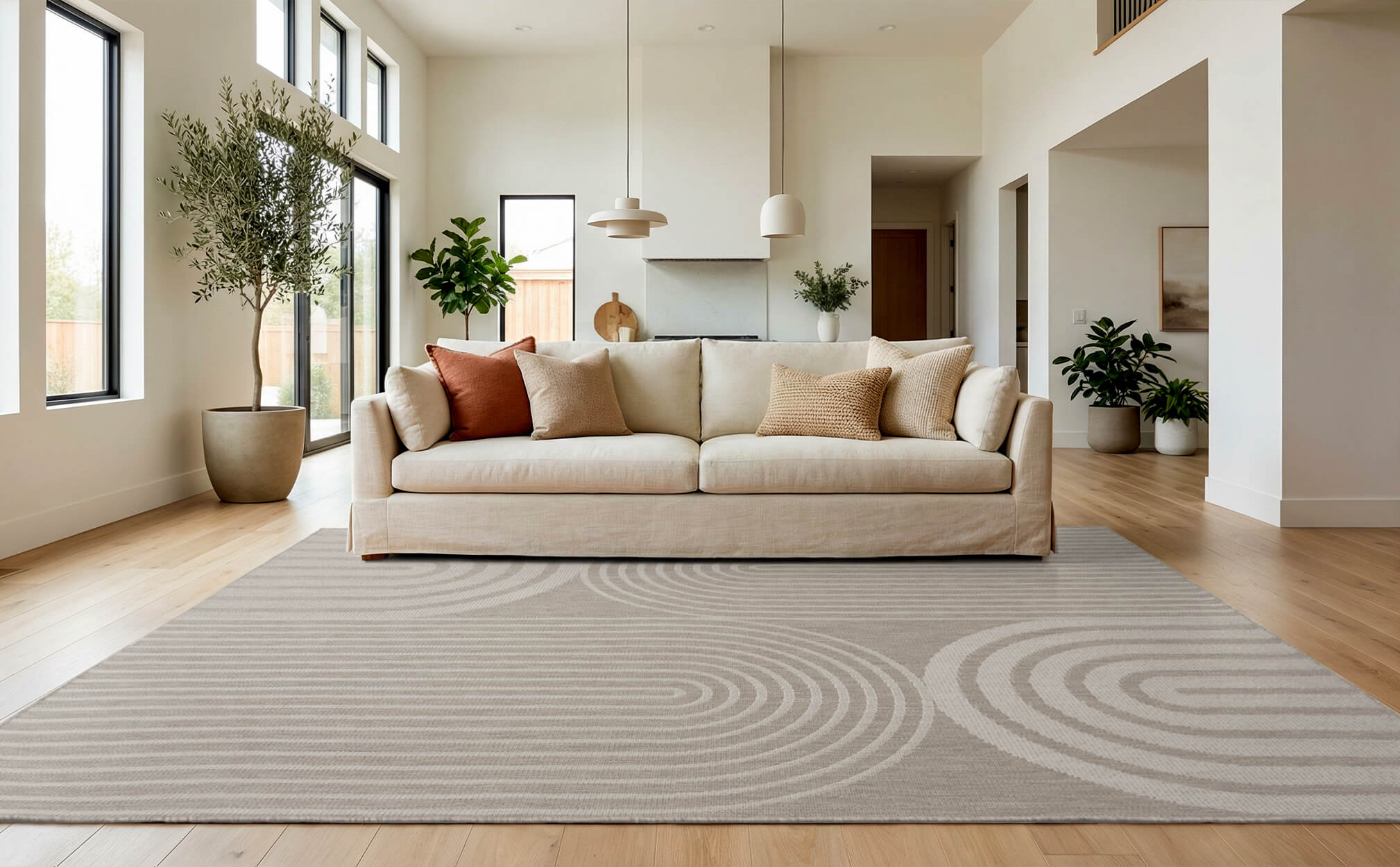 A light gray abstract indoor outdoor area rug with a modern arch line pattern adds clean texture to a bright living room with a cream sofa, wood floors, and airy contemporary decor.