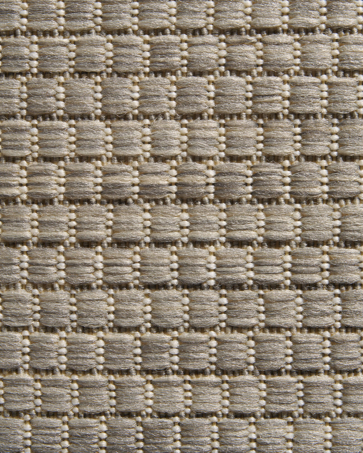 A close-up view of a light gray plain weave outdoor rug highlights its raised basketweave texture, durable woven surface, and clean natural style for patios, decks, porches, and outdoor entryways.