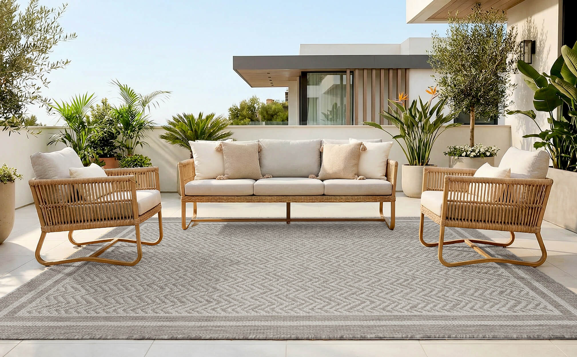 Faux jute indoor outdoor rug with soft scroll pattern detailing and relaxed woven texture