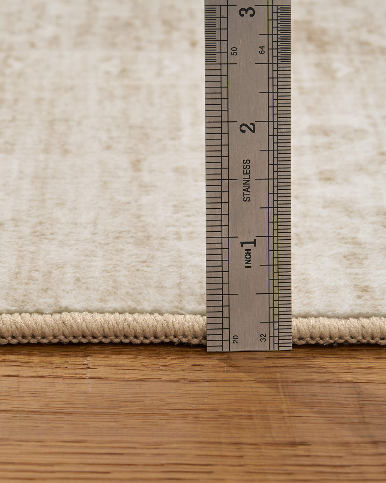 A low-profile beige vintage washable area rug features a soft distressed surface and reinforced edge, making it easy to place under furniture and ideal for cozy living rooms, bedrooms, and high-traffic spaces.