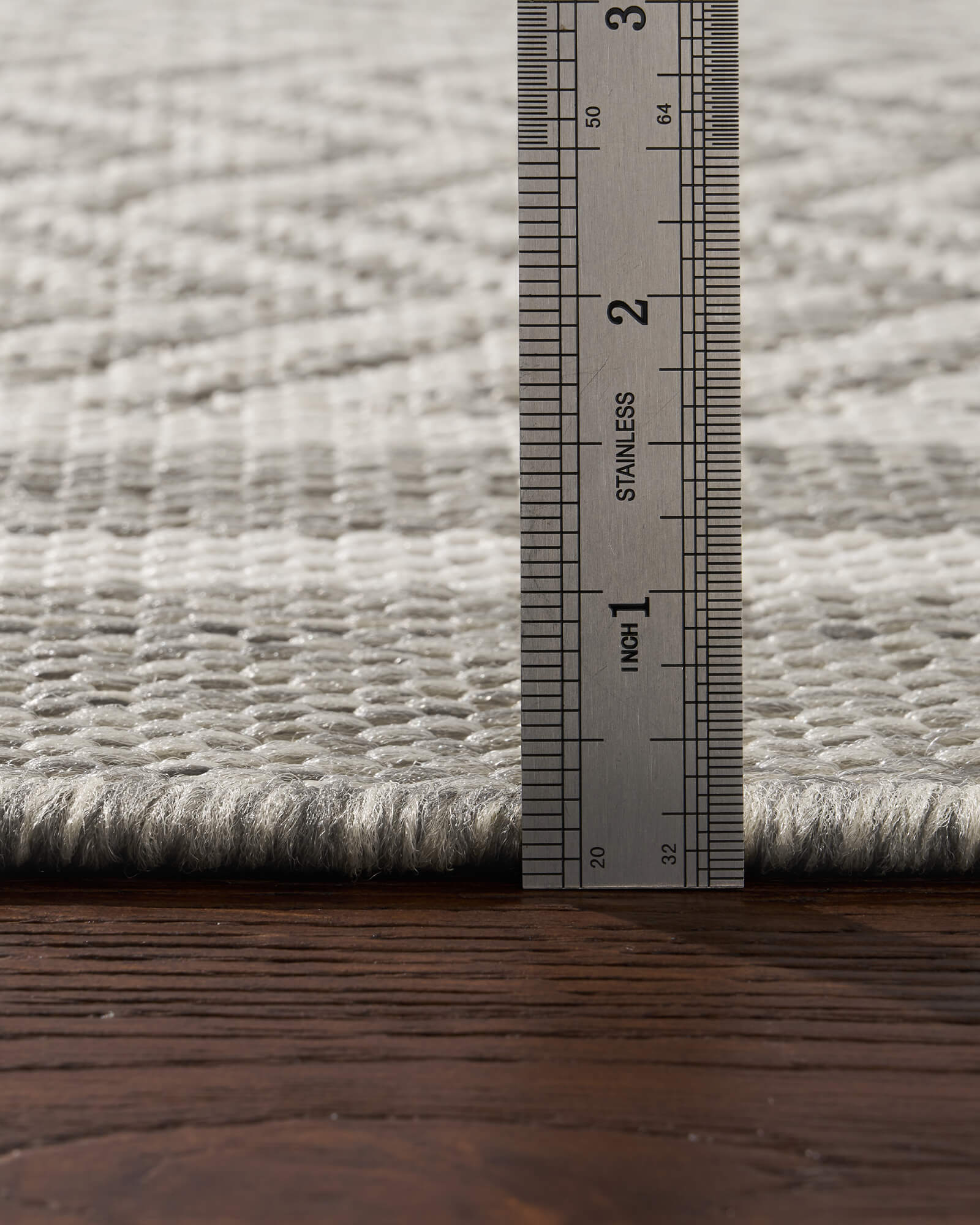 A low-profile gray chevron indoor outdoor rug features a durable woven texture and slim pile height, making it easy to place under patio furniture, dining tables, and high-traffic living spaces.