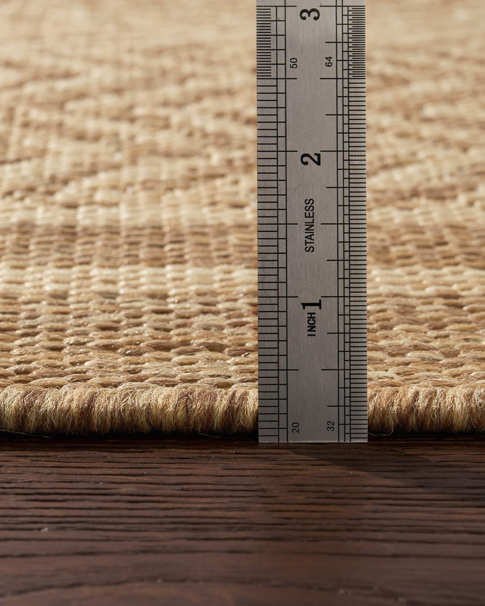 A low-profile natural chevron indoor outdoor rug features a durable woven texture and slim pile height, making it easy to place under patio furniture, dining tables, and high-traffic living spaces.