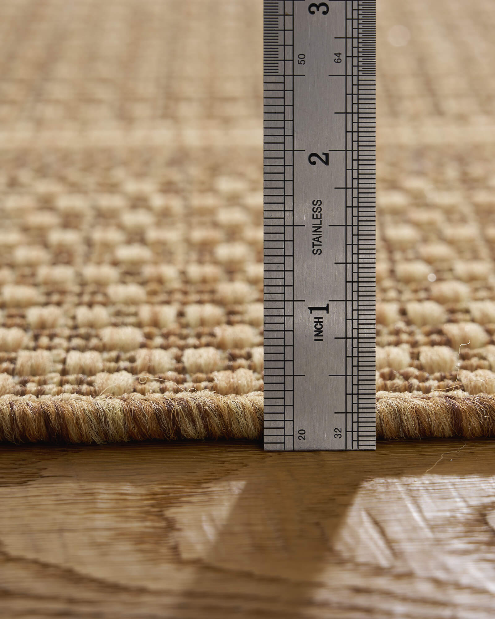 A low-profile natural woven indoor outdoor rug features a durable jute-look texture and slim pile height, making it easy to place under furniture and ideal for patios, kitchens, porches, and high-traffic spaces.