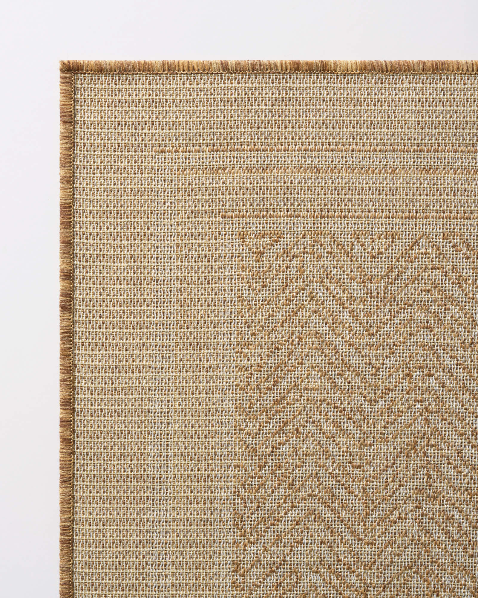 A close-up view of a natural chevron indoor outdoor rug shows its durable woven texture, reinforced border edge, and easy-care design for patios, porches, dining areas, and high-traffic spaces.