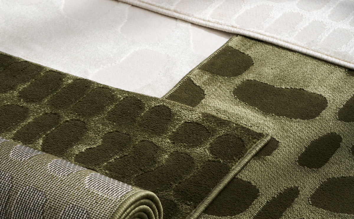 A close-up comparison of olive green and ivory luxury Wilton jacquard rugs highlights their raised dimensional patterns, refined bound edges, structured woven backing, and premium tonal texture for elevated home decor.