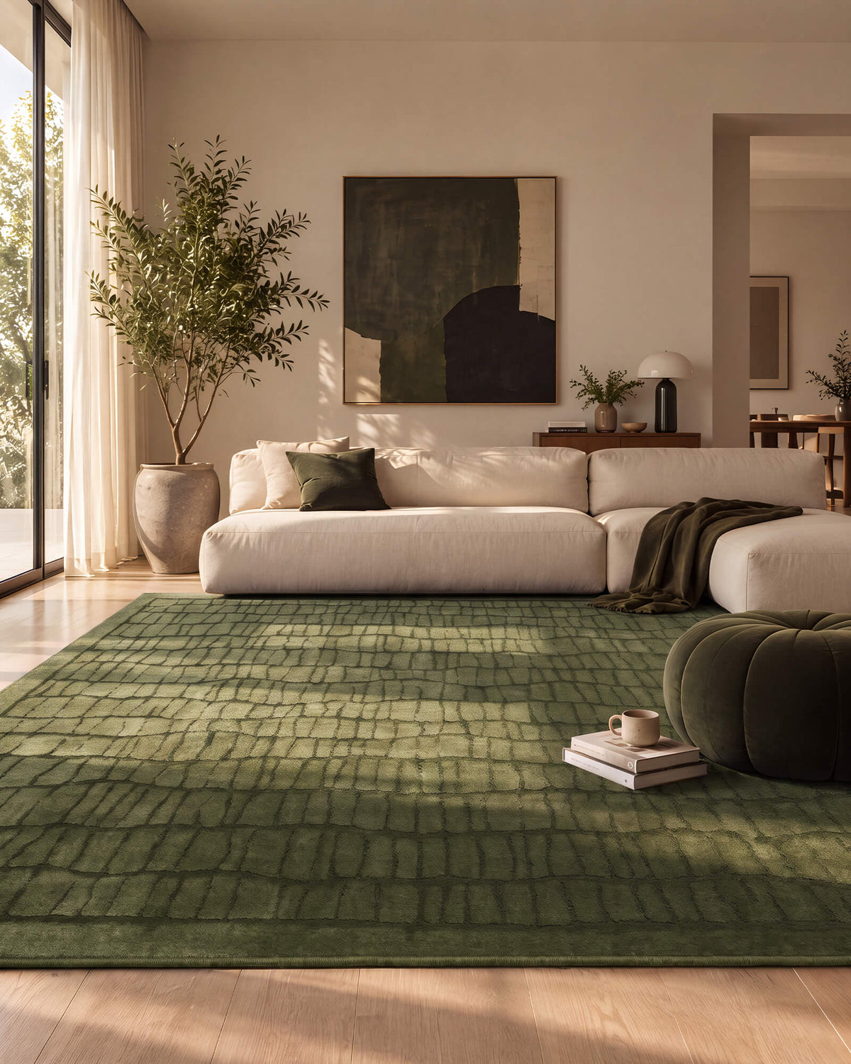 An olive green luxury Wilton jacquard area rug with a raised grid texture adds dimensional depth to a refined modern living room with a cream sectional sofa, sculptural ottoman, warm sunlight, and curated designer decor.