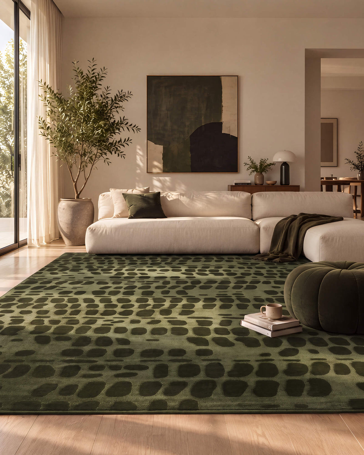 An olive green premium Wilton jacquard area rug with a raised geometric pattern brings sculptural texture and refined depth to a luxury living room with a cream sectional sofa, warm sunlight, and designer-inspired decor.