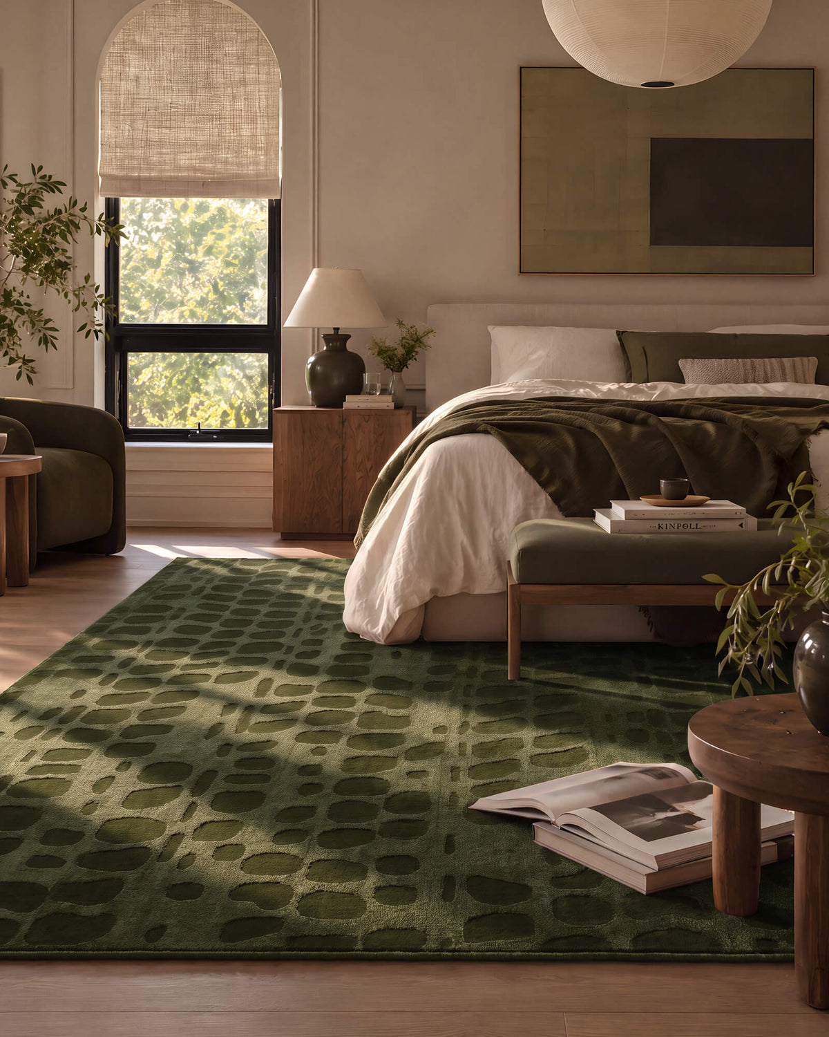 An olive green premium Wilton jacquard area rug with a raised geometric pattern adds rich texture and quiet luxury to a refined bedroom with warm wood furniture, layered bedding, and soft natural light.