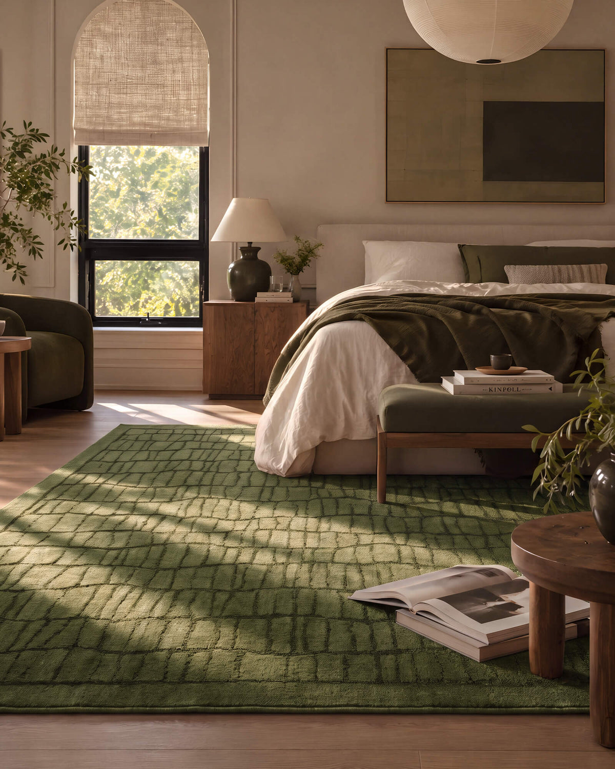 An olive green premium Wilton jacquard area rug with a raised grid pattern adds sculptural texture and rich tonal depth to a refined bedroom with layered bedding, warm wood furniture, and soft natural light.