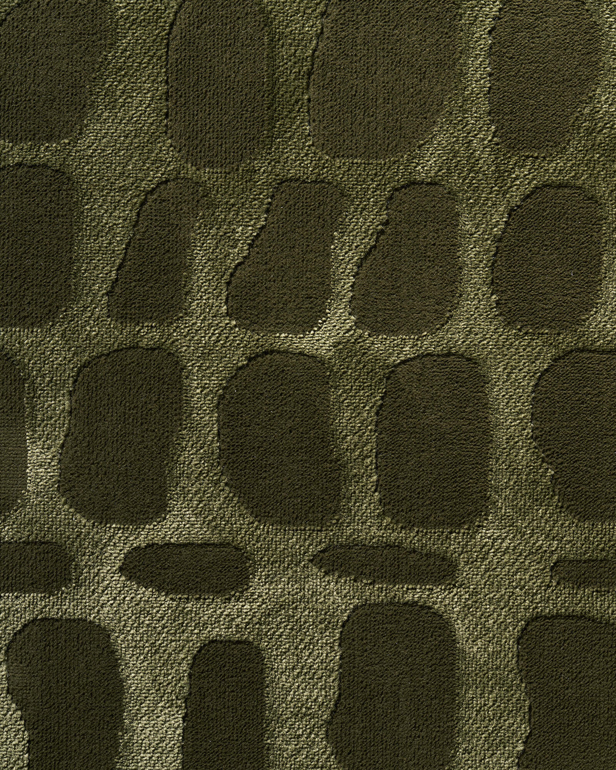 A macro close-up of an olive green premium Wilton jacquard rug highlights its raised pebble-inspired pattern, dimensional woven texture, and rich tonal depth for elevated living room and bedroom styling.