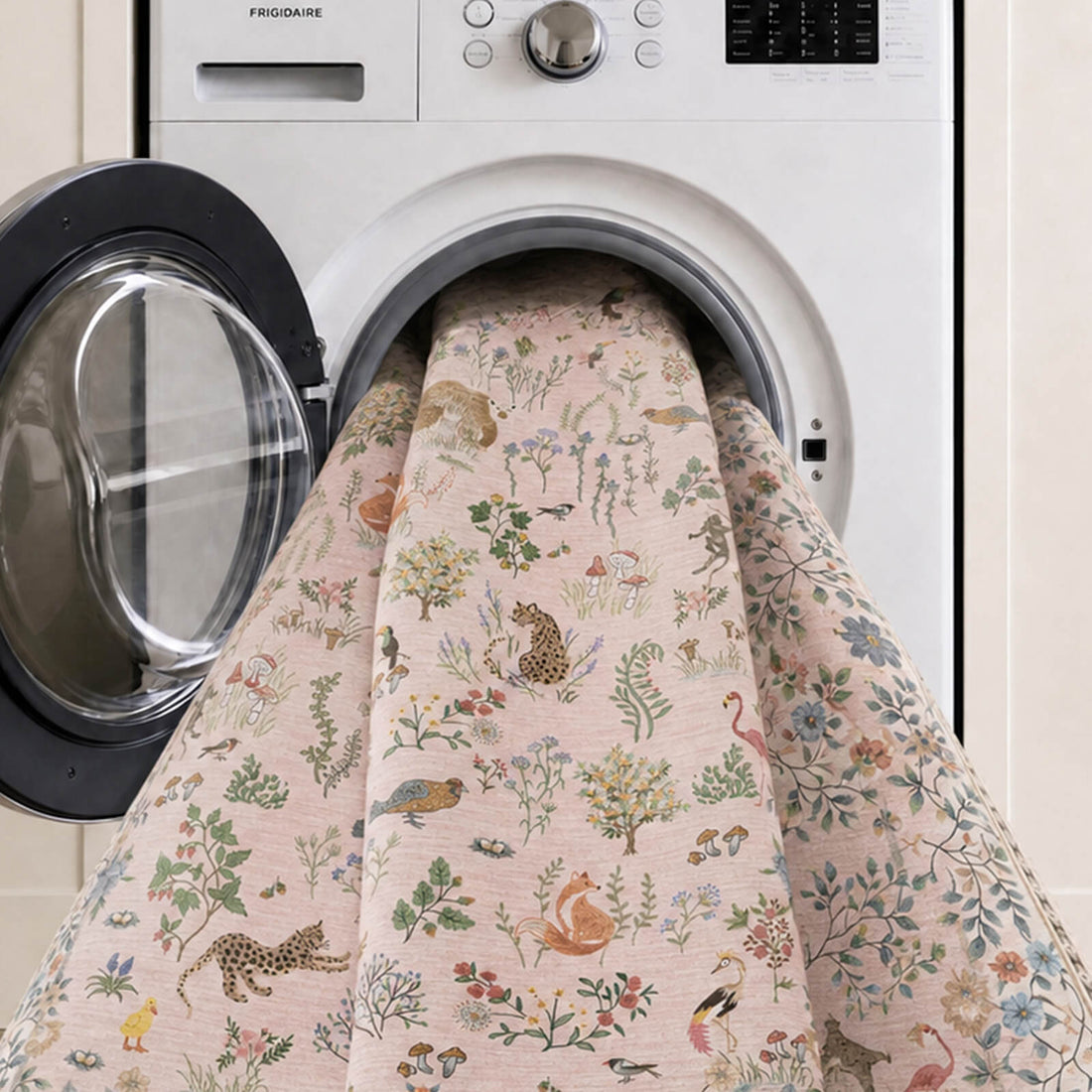 A pinksoft kids rug is shown in a washing machine, featuring cute forest animals, birds, mushrooms, and floral illustrations with a gentle comfortable surface and easy-care design for nurseries, playrooms, and children’s bedrooms.