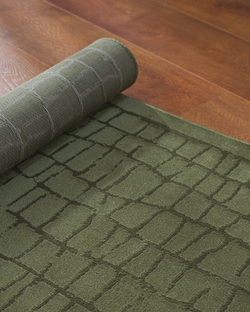 A close-up video of a high-end jacquard area rug features its raised pattern, neatly bound edge, and premium construction for refined living rooms, bedrooms, and designer-inspired interiors.
