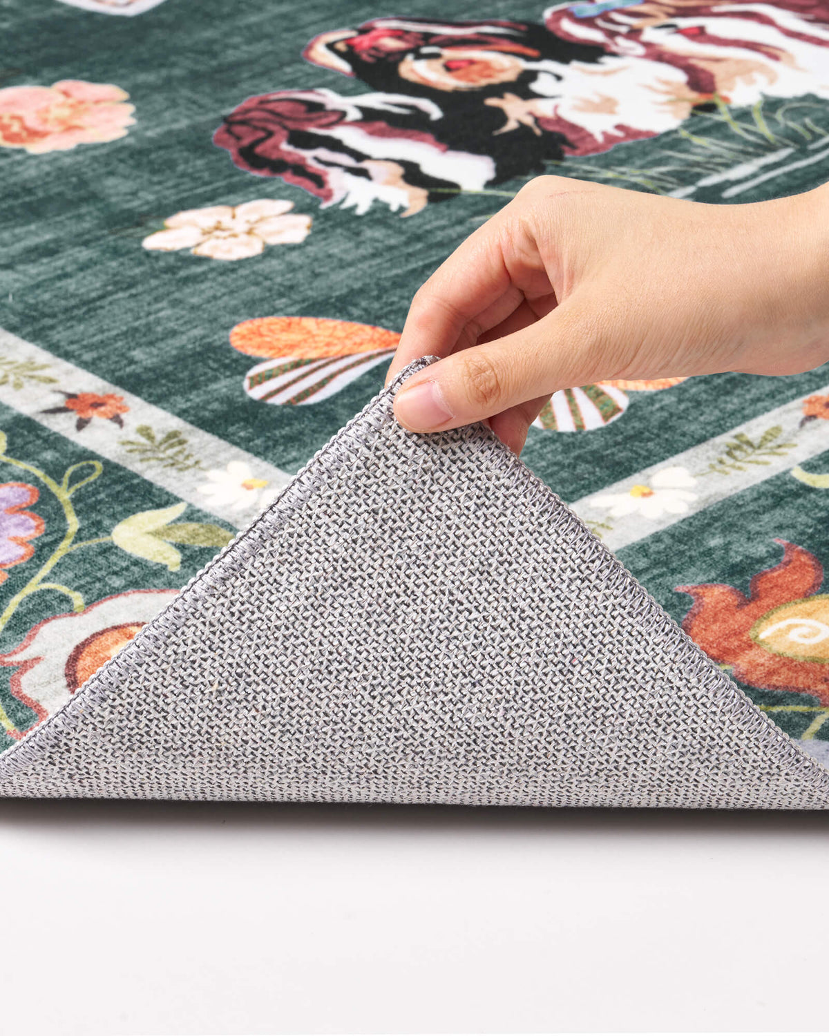 A close-up view of a teal soft kids rug showing its folded corner, gray non-slip backing, cute animal border pattern, and neatly finished edge for safe, cozy nursery, playroom, and children’s bedroom use.