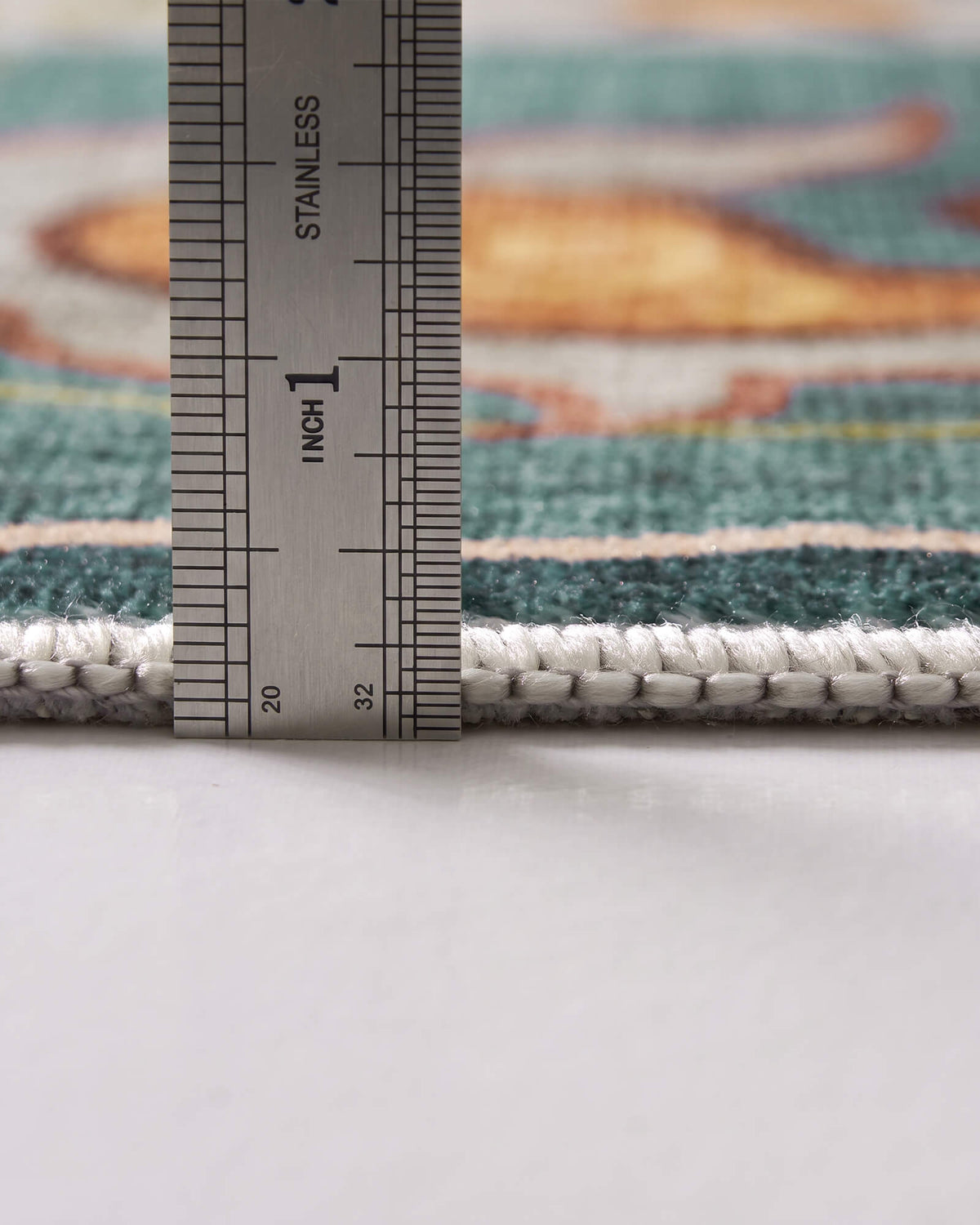 A close-up view of a teal soft kids rug showing its ruler-measured pile height, plush comfortable surface, and neatly bound edge for safe and cozy playroom, nursery, and children’s bedroom use.