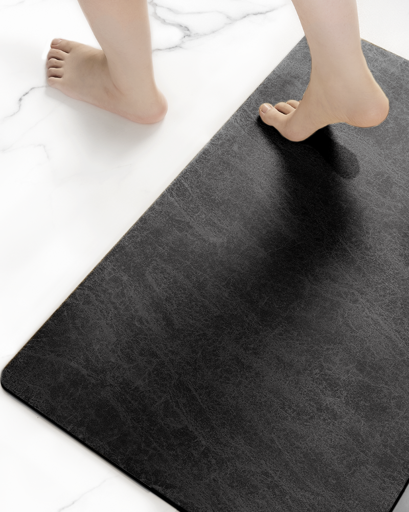 Thin bath mat designed to fit under doors without curling, offering fast drying comfort for compact bathroom layouts
