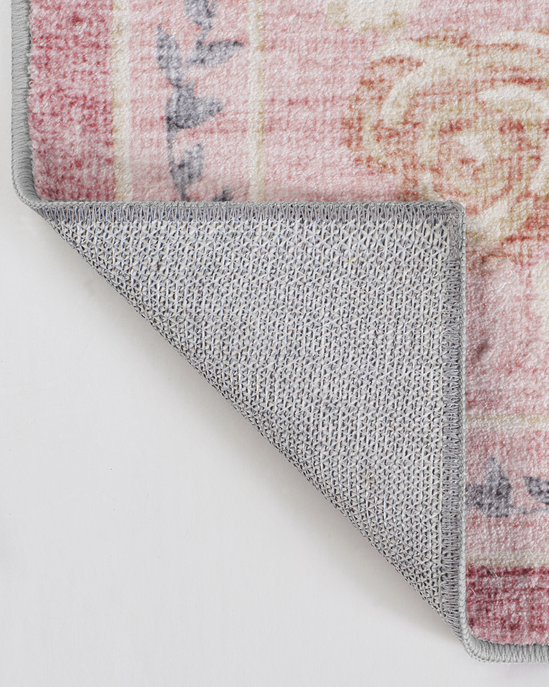 Detailed view of non-slip backing on a vintage area rug for safe placement