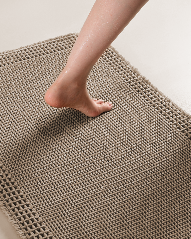 Waffle bath mat designed to absorb moisture and dry quickly between uses