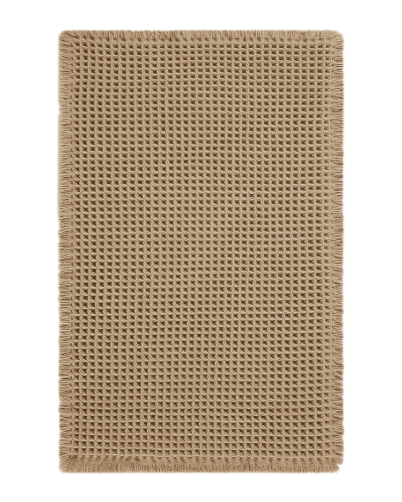 Waffle texture bath mat with decorative tassels, designed to absorb moisture quickly while adding warmth to bathroom décor